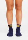 THE UPSIDE women’s navy cotton Salvador Grip Sock is anti slip and has a terry sole with striped yellow midi ankle height. Made for yoga and pilates.