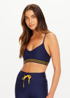 THE UPSIDE women’s navy recycled Eco Tech Salvador Zoe Sports Bra is breathable and features a scooped low neckline, T-bar back and adjustable straps. Made for yoga and pilates.