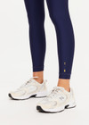 THE UPSIDE women’s navy recycled Eco Tech Salvador 25inch Midi Legging is mid rise and features side seam pockets, a cuffed hem and drawcord waist. Made for yoga and pilates.