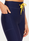 THE UPSIDE women’s navy recycled Eco Tech Salvador 25inch Midi Legging is mid rise and features side seam pockets, a cuffed hem and drawcord waist. Made for yoga and pilates.