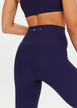 THE UPSIDE Peached Florence Flare in Navy is a sustainable high-rise full length flare pant with “V” waistband detail and printed arrow logo at back waistband.