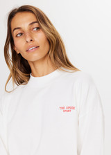 THE UPSIDE Courtsport Sabine Top in White is a sustainable organic cotton cropped long sleeve top with ribbed mock neck, printed THE UPSIDE SPORT college logo in red and drop shoulders.