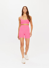 THE UPSIDE womens neon pink mid-rise Ribbed Seamless 5 Inch Spin Short made with Ribbed Seamless fabric features reverse rib panelling and moisture control properties. Perfect for yoga, pilates and barre.