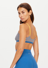 THE UPSIDE womens low-coverage navy and white striped Rise Ballet Bra made with Recycled Peached fabric features contrasting yellow adjustable elastic straps, blue underbust band and moisture wicking properties. Ideal for yoga, pilates and barre.