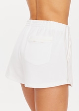 THE UPSIDE womens white mid-rise Pasadena Nova Short made with organic cotton features an elasticated waistband, side and back pockets, and stripe down side seam.