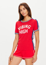 THE UPSIDE women’s red retro slim fit Iro Sutton Tee made with lightweight cotton viscose knit blend features contrast navy and white stripes down sleeves and side seams, striped rib neck and armholes, embroidered “Vibing High” on front, and embroidered “3” on back.