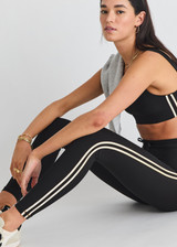 THE UPSIDE women's black Beaufort 25inch Midi Pant is made from recycled soft peached fabric with a brushed handfeel and breathable, moisture-wicking properties. This legging features contrast binds at the sides and a drawcord waistband.