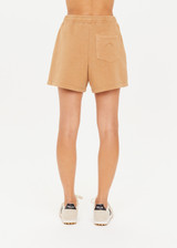 THE UPSIDE women's tan/dune Tecopa Darcy Short features a long-line shape, an elasticated waistband, patch pockets on front and back, and embroidered horseshoe logo on back pocket.