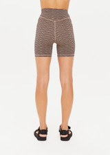 THE UPSIDE women's metallic Libertine 5 Inch Spin Short, made in specialty fabrication with a navy base and gold zig-zag design, features a mid rise fit, 5 inch leg length, and embroidered arrow on back.