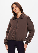 THE UPSIDE women's chocolate-brown cropped Carlotta Jacket made with recycled polyester features a collar, ribbed cuffs, side seam pockets, embossed apple leather patch on back and elastic hemband.