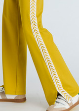 THE UPSIDE women's honeycomb yellow Ren Petra Flare is a flared pant with splits at front, contrast tape down side seams cream tape down the side seams, pockets and elastic at waist.