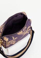 THE UPSIDE women's floral print Fleur Cosmic Crossbody Bag is made with 100% recycled fabric. This crossbody bag features internal pockets and an adjustable strap.