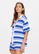 THE UPSIDE women's tonal white and blue striped Haven Lovett Crochet button through Shirt is made from hand crocheted cotton and features a collar and pink buttons and contrast stripes.