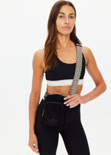 THE UPSIDE women's black Journey Crossbody Bag is made from corduroy fabric. This compact bag features a front zip pocket, larger zipper compartment with paracord zip pullers and adjustable, removable strap.