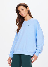 THE UPSIDE women's blue One Love Club Coolum Crew is made in brushed organic cotton. Fitted with a ribbed neckline, cuffs and hem for style and discreet side seam pockets for practicality. Designed for walking and recovery.