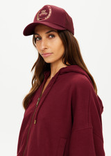 THE UPSIDE women's maroon Cheval Classic Trucker Hat features a foam front and mesh back with an adjustable snapper.