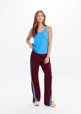 THE UPSIDE women's maroon Ryder Petra Flare Trackpant feature blue side stripes, a split hem, elasticated waist and side pockets.