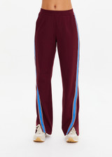 THE UPSIDE women's maroon Ryder Petra Flare Trackpant feature blue side stripes, a split hem, elasticated waist and side pockets.