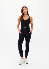 THE UPSIDE women's Peached 25 Inch Pocket legging is a mid rise 7/8 length leg in black with side pockets and a stretch drawcord waistband. The fabric is breathable and quick drying.