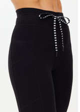 THE UPSIDE women's Peached 25 Inch Pocket legging is a mid rise 7/8 length leg in black with side pockets and a stretch drawcord waistband. The fabric is breathable and quick drying.