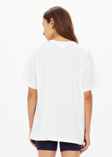 THE UPSIDE women's cream organic cotton Raceway Sammi Tee is designed for an oversized fit with printed raceway graphics on the front.