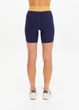 THE UPSIDE women's navy recycled peached Daytona 6 Inch Spin Short is designed for a mid-rise fit featuring contrast cream binds. Made for yoga & pilates.