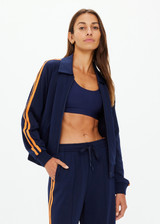 THE UPSIDE women's navy Vitesse Pari Zip Jacket comes in a slinky fabrication with mesh side tapes in contrast orange and side pockets. Designed for everyday leisure.