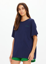 THE UPSIDE women's navy organic cotton Sammi Tee is an oversized fit and features The Upside logo on front and a printed palm tree sunset design on back. Made for lifestyle.