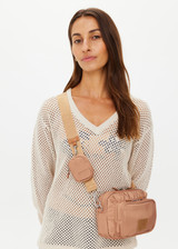 THE UPSIDE women's tan recycled fabric Odyssey Crossbody Bag features an adjustable and removable strap, multiple zippered pockets and silver hardware.