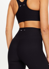 THE UPSIDE women's black Peached Florence Flare is a high-rise full length flare pant with V waistband and a printed arrow logo on back waistband.
