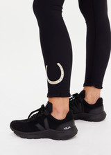 THE UPSIDE women's black recycled peached Celestia 25inch Legging is a soft & supportive fit and features a drawcord and printed star and horseshoe on ankles. Made for yoga & pilates.
