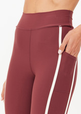 THE UPSIDE women's red recycled peached Samara 25inch Legging is a soft & supportive fit and features side pockets and contrast cream stripes with curved hem detail. Made for pilates.