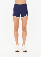 THE UPSIDE women's navy recycled peached Samara 3.5inch Spin Short offers a soft & supportive fit and features side pockets and contrast cream stripes . Made for pilates.