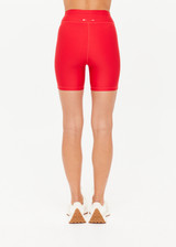 THE UPSIDE women's red eco tech Oxford 5-inch Spin Short is supportive and comfortable with mid-rise, cream side stripes, and elastic waist drawcord. Made for high impact.