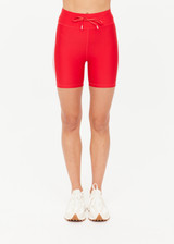 THE UPSIDE women's red eco tech Oxford 5-inch Spin Short is supportive and comfortable with mid-rise, cream side stripes, and elastic waist drawcord. Made for high impact.