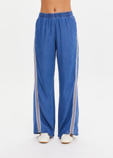 THE UPSIDE women’s blue Lykke Juliet Pant in soft chambray features a low-rise fit, split hem, and contrasting mesh knit side stripe. The perfect travel pant.