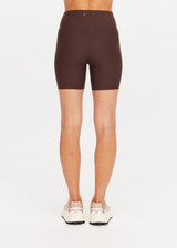 THE UPSIDE women's brown high-waisted Peached 5inch Spin Short offers a soft & supportive fit in recycled peached fabric and features a printed arrow logo on back waistband. Made for pilates & yoga.