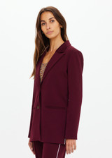 THE UPSIDE women's maroon Mendoza Boyfriend Blazer is designed as a boyfriend style single breasted blazer with cream piping along side seams, tortoiseshell buttons and front welt pockets.