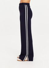 THE UPSIDE women's navy Monte Carlo Freya Knit Pant fits true-to-size and features an elasticated waistband with belt and knitted white side stripes. Made for lifestyle.