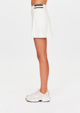THE UPSIDE women's cream recycled soft peached Courtship Becket Mini Skirt is a panelled tennis skirt featuring an internal short external pockets with contrast striped elastic detailing at waistband. Made for tennis, gold & pickleball.