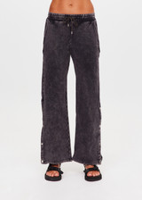 THE UPSIDE women's washed black Cosmic Wide Leg Shana Pant is a high waisted, wide-leg fit and features silver metal button snaps down leg that can be worn open.