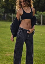 THE UPSIDE women's washed black Cosmic Wide Leg Shana Pant is a high waisted, wide-leg fit and features silver metal button snaps down leg that can be worn open.