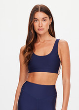 THE UPSIDE women's navy eco tech Toscan Harley Scoop Sports Bra is designed for mid coverage with a scoop front and back neckline, featuring removable cups and crafted with contrast mocha and cream binds. Made for yoga & pilates.