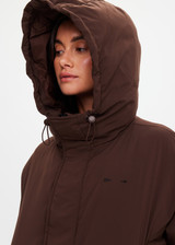 THE UPSIDE women's brown Mercer Hooded Puffer Jacket is fully lined and features invisible zip pockets with fleece lining, soft elasticated cuffs, a hood and is made from recycled fabric. Made for lifestyle.