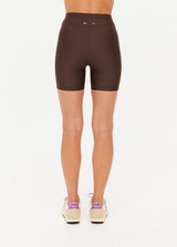THE UPSIDE women's brown eco tech Oxford 5Inch Spin Short offers a mid rise with lilac coloured binds down side seams and an elastic drawcord through waist. Made for high impact.