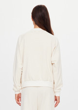 THE UPSIDE women's cream Navar Isabella Bomber Jacket is an oversized fit with raglan sleeves in our castilla "TU" design and features a front patch pocket, crafted from a knitted jacquard fabrication. Made for everyday wear.