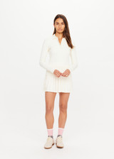 THE UPSIDE women’s cream recycled Cruz Collared Polo is long sleeved with a ribbed collar and moisture wicking fabrication. Made for running.
