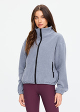 THE UPSIDE women’s grey recycled Sol Fleece Jacket has a relaxed fit with elastic waist and arm cuffs with polar fleece fabrication in marle. Made for lifestyle.