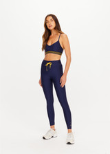 THE UPSIDE women’s navy recycled Eco Tech Salvador Zoe Sports Bra is breathable and features a scooped low neckline, T-bar back and adjustable straps. Made for yoga and pilates.