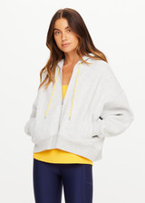 THE UPSIDE women’s grey marle organic cotton Jude Crop Hoodie offers an oversized fit and features a zip through front, hood with drawcord and ribbed cuffs and hem. Made for lifestyle.